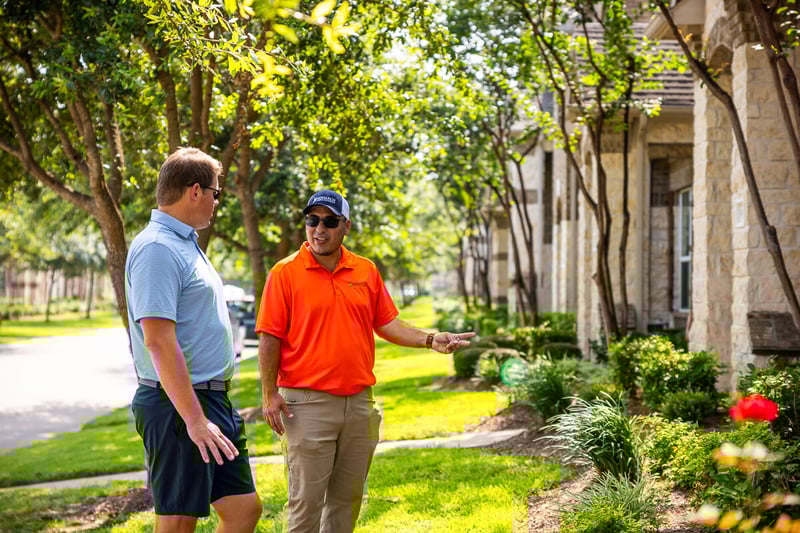 property manager and customer inspect landscape