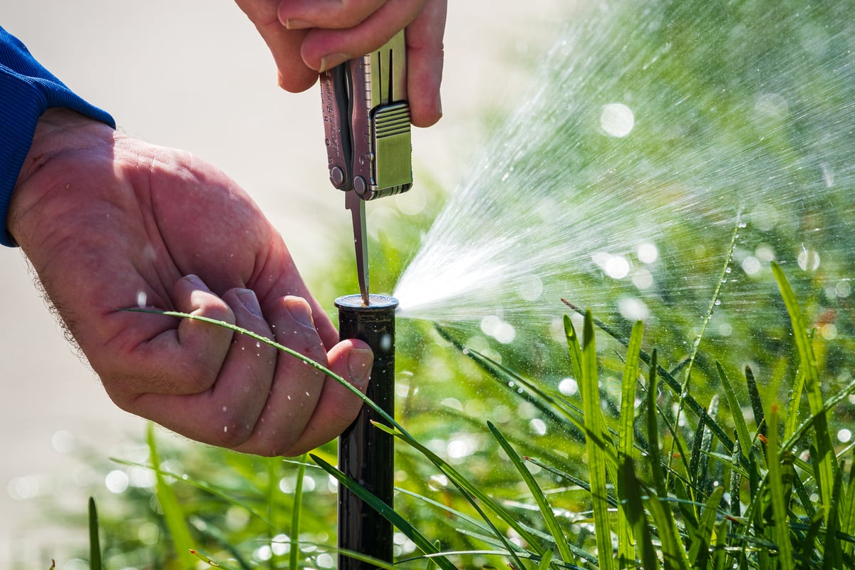 irrigation experts adjust sprinkler system heads
