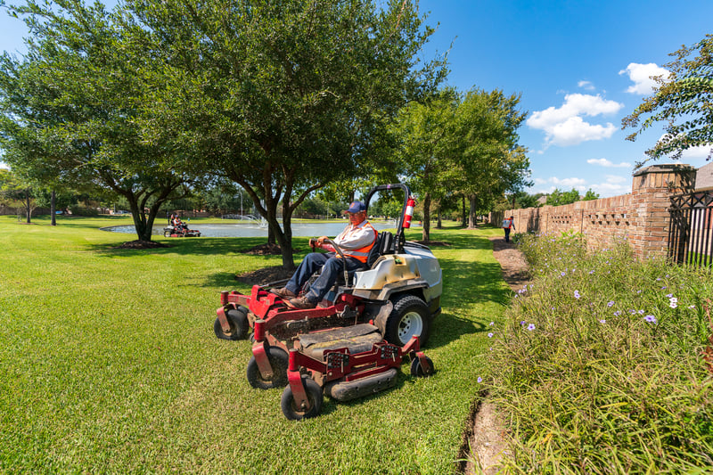 landscape maintenance team mows commercial property
