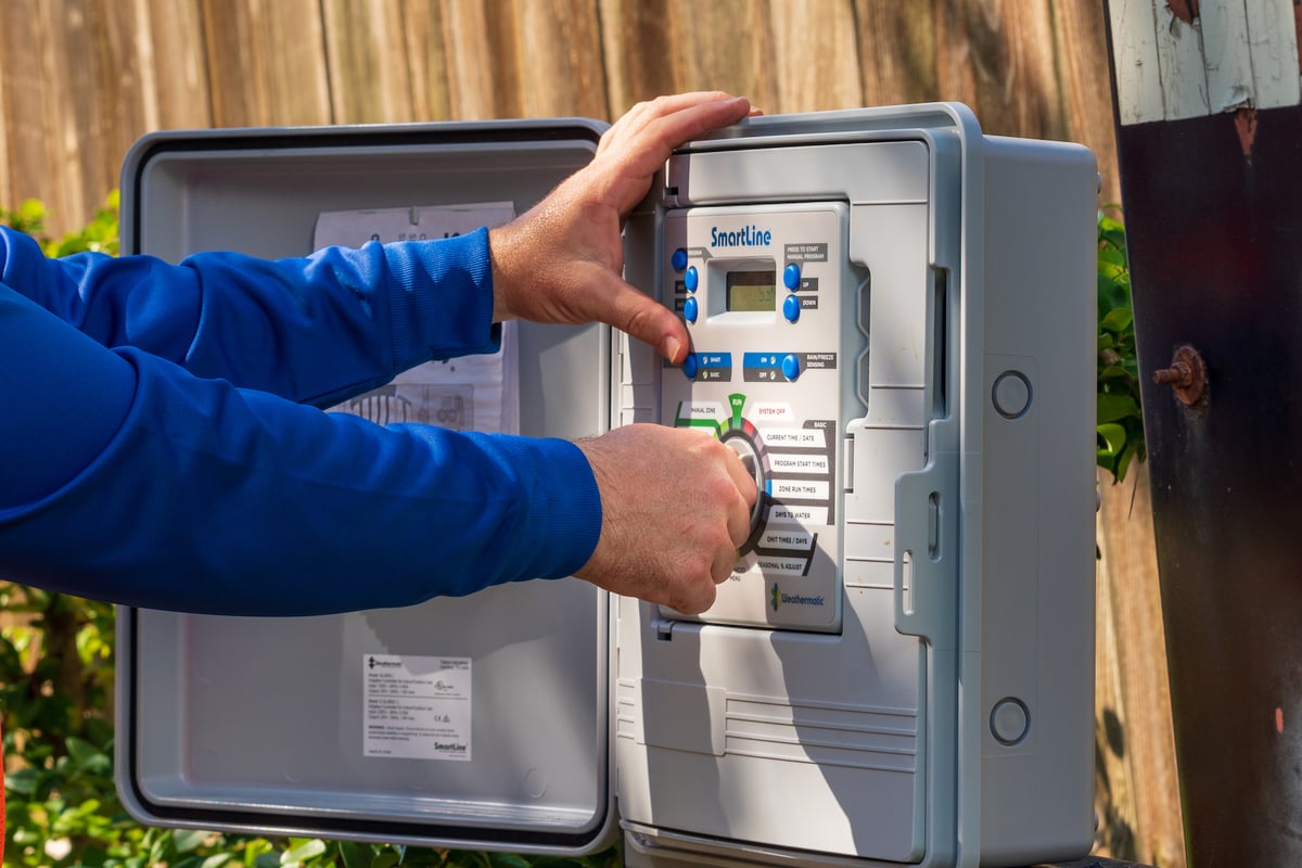 landscape experts adjust sprinkler controls