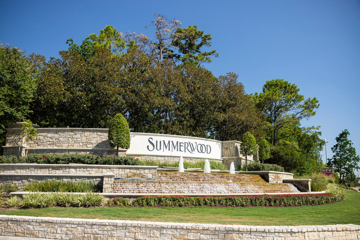 sign with plantings, retaining walls and water feature