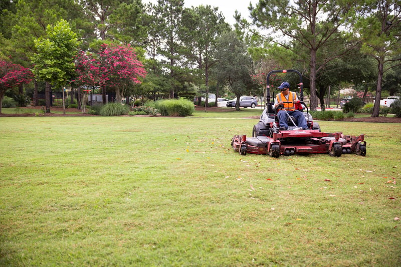 landscape maintenance team mows lawn